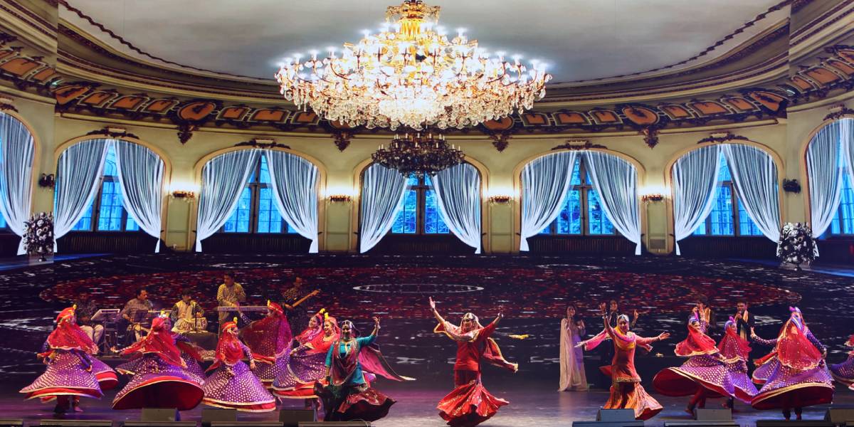 dancers in a room with a chandelier